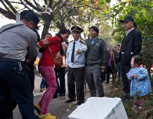 城管与女小贩发生冲突后,女小贩被警方强行带走,她的孩子在一旁放声大哭。南都记者 黎湛均 摄