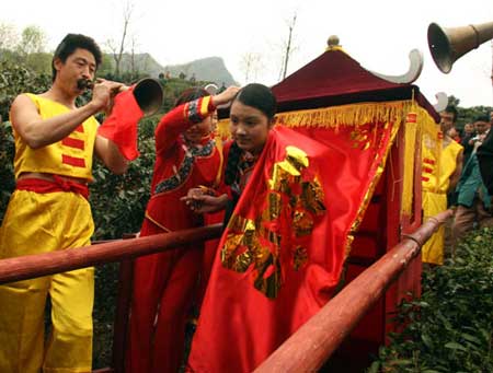一名土家族采茶姑娘走出花轿，参加祭茶仪式 